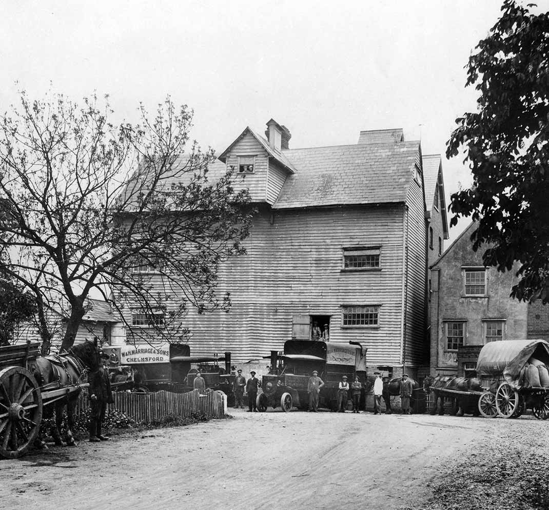 Image of an old black and white photograph of Marriage's mill with horses and carts outside